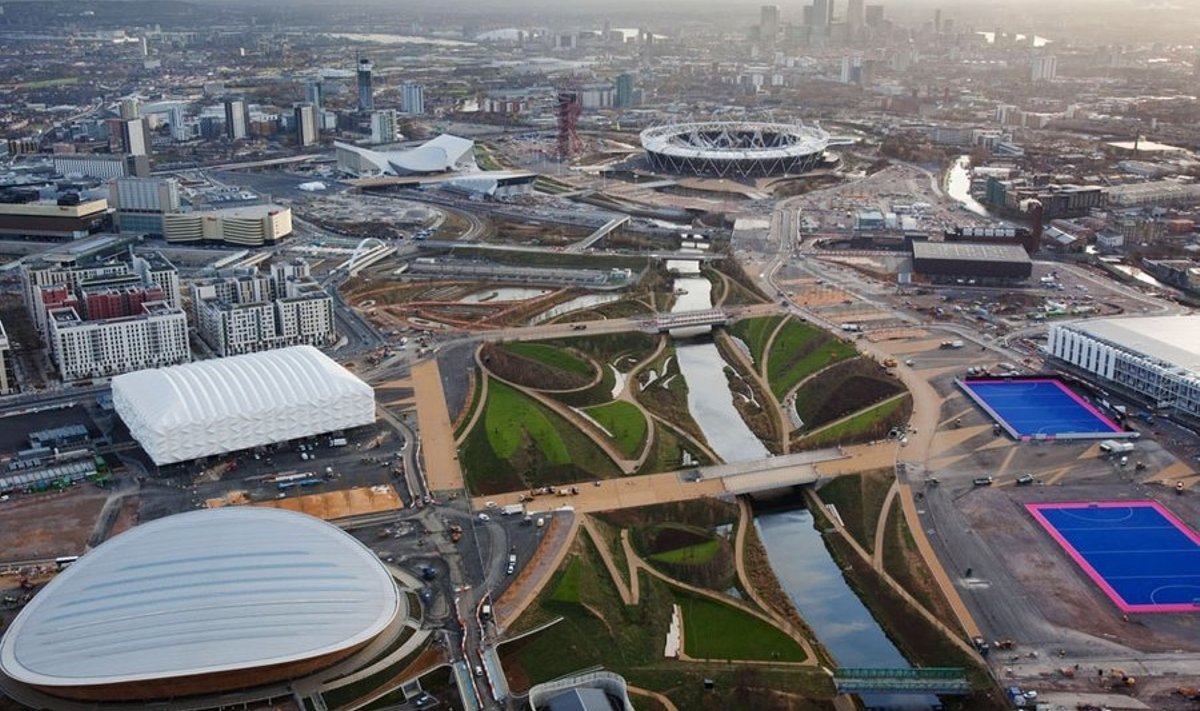 Veel ehitusjärgus olevas olümpiapargis on kenasti näha pargist läbi jooksvat Lea jõge ümbritsevad rohealad. Vasakule jäävad velodroom ja korvpallihall, paremale maahokiväljakud. Taamal paistab olümpiastaadion. Foto: London2012.com