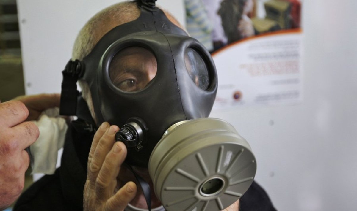 An Israeli man tries on a gas mask at a distribution center in a post office in the town of Or Yehuda, near Tel Aviv, Sunday, Feb. 28, 2010. The Israel Defense Forces Home Front Command began distributing gas mask kits to the public on Sunday. The plan is to distribute the kits to the entire population by 2013. (AP Photo/Ariel Schalit) / SCANPIX Code: 436