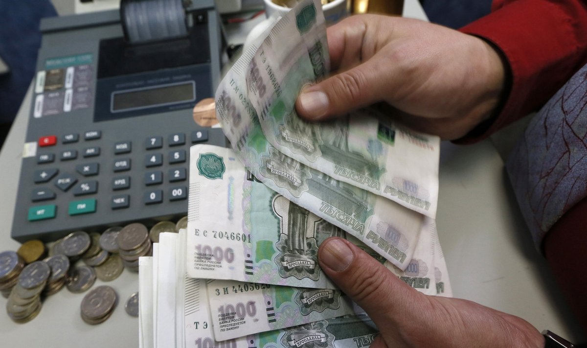 An employee counts Russian Rouble banknotes at private company's office in Krasnoyarsk