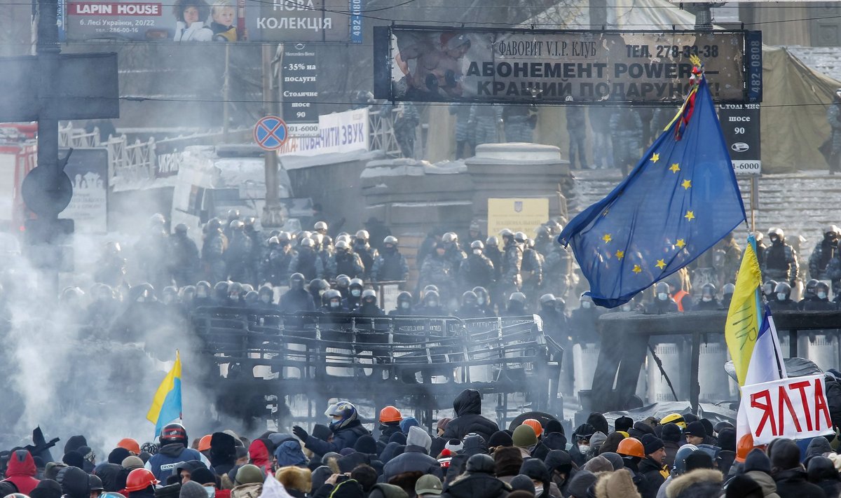 People gather at the the site of clashes between pro-European integration protesters and riot police in Kiev
