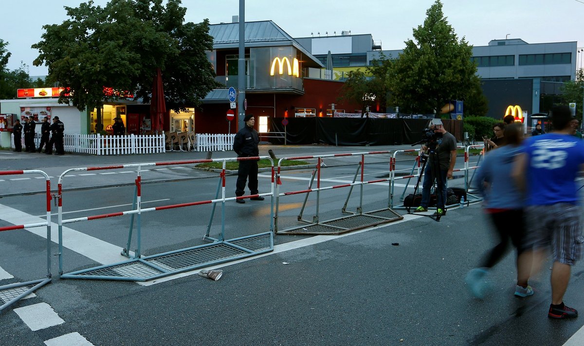 Police stand guard outside a McDonalds fast food restaurant near the Olympia shopping mall, where yesterday's shooting rampage started, in Munich