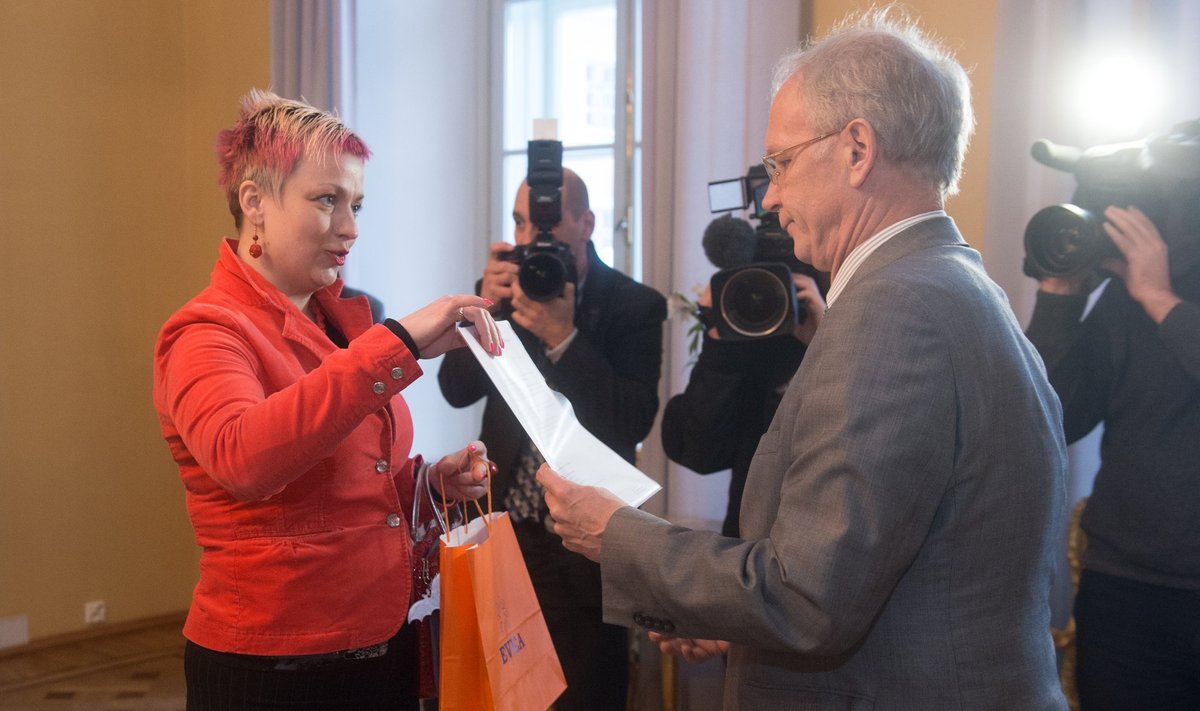 EVEA kommunikatsiooni- ja õigusdirektor  Kristi Hunt annab Eiki Nestorile allkirjad üle. 