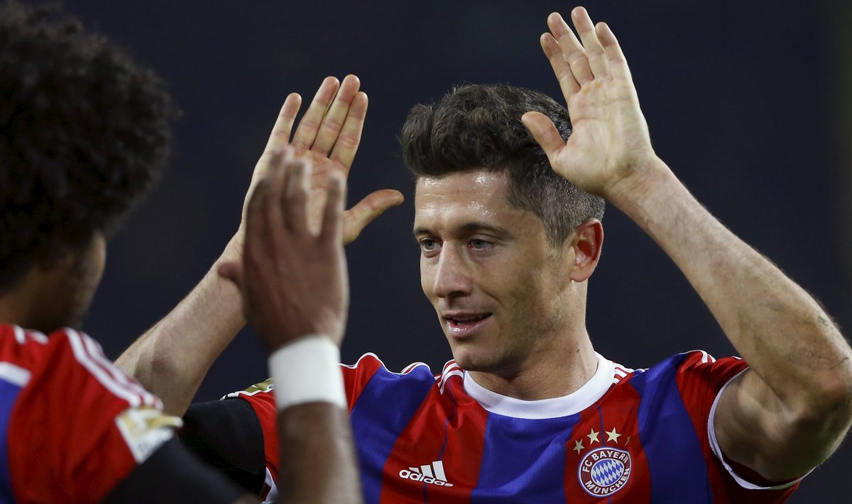 Lewandowski of Bayern Munich celebrates with Dante following their German first division Bundesliga soccer match against Borussia Dortmund in Dortmund