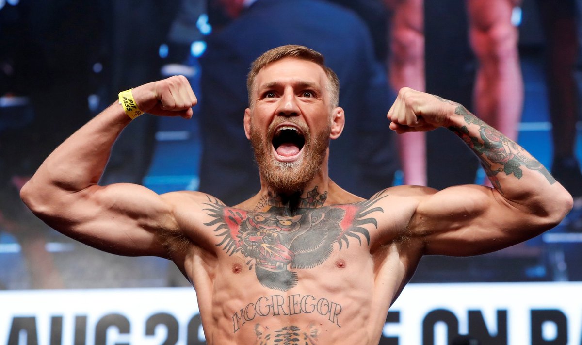 UFC lightweight champion Conor McGregor of Ireland poses on the scale during their official weigh-in at T-Mobile Arena in Las Vegas