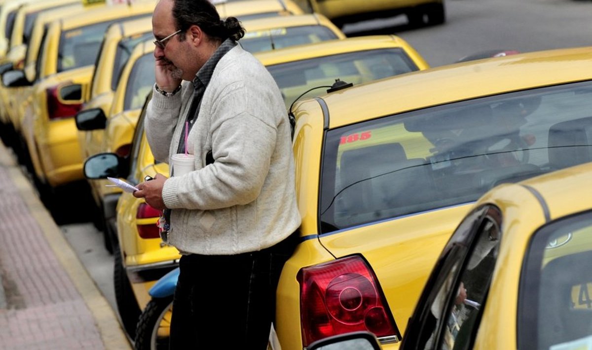 A taxi driver stands next to parked taxis  during a 48hours strike in Athens on April 14, 2010. Greece suffered a new setback on Wednesday when its borrowing rate shot up again to above 7.0 percent, just as taxi drivers and lawyers began a new series of strikes against huge budget cuts. AFP PHOTO / Aris Messinis