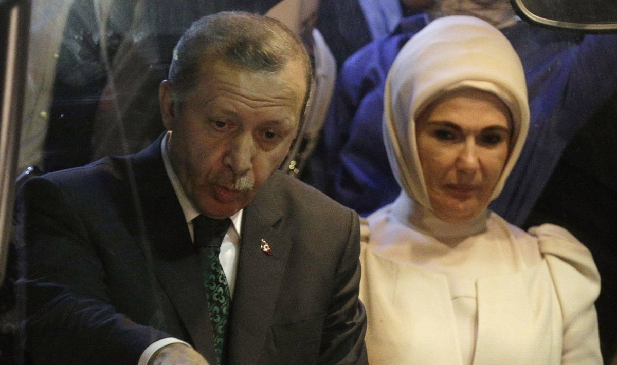 Turkey's Prime Minister Erdogan points to supporters next to his wife Emine after arriving at Istanbul's Ataturk airport