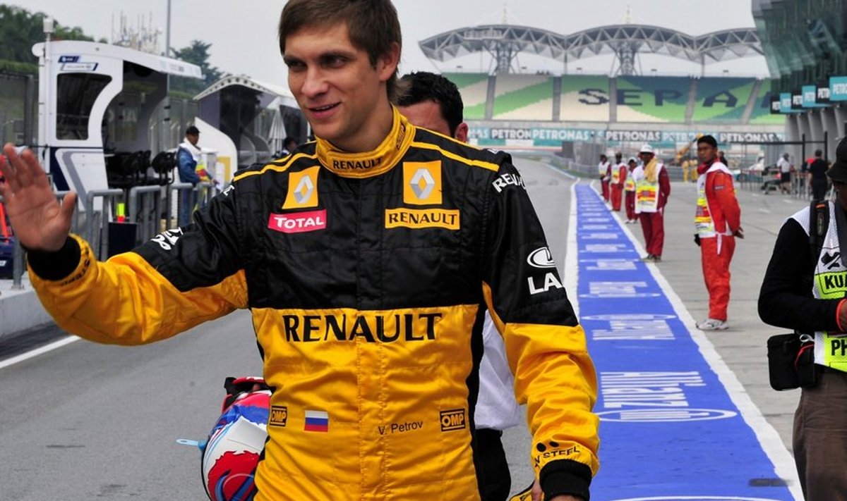 Renault driver Vitaly Petrov of Russia waves to teammates in the pit lane during the first practice session for Formula One's Malaysian Grand Prix in Sepang on April 2, 2010. The drivers are taking part in the practice sessions for the Grand Prix which will be run on April 4.  AFP PHOTO/ Saeed KHAN