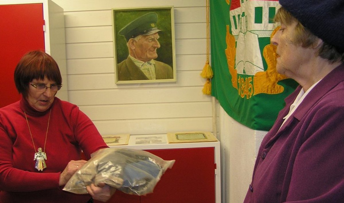 Eha Kaljusaar näitab muuseumi kogus olevat vana Eesti lippu. Paremal Aino Mitt. Foto: Reet Saar