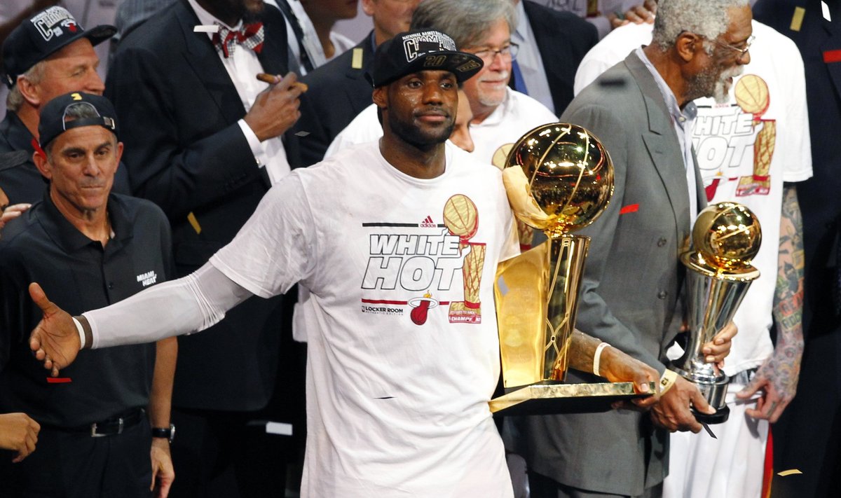 Miami Heat's James holds the Larry O'Brien Championship Trophy as NBA great Russell holds the MVP trophy following the Heat's victory over the Spurs in Game 7 of their NBA Finals basketball playoff in Miami