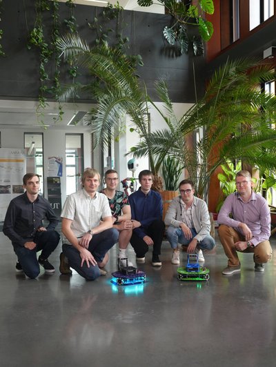 : Robootika suuna ühed peamised eestvedajad Karl Kruusamäe ja robotitehnoloogia lektor Veiko Vunder (vasakult teine) koos arvutitehnika üliõpilastega. Raimo Köidami (keskel tumesinises) bakalaureusetöö tulemusena välgutab Robotont nüüd leede. 