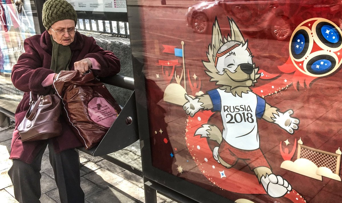 Pensionär Moskva bussipeatuses jalgpalli maailmameistrivõistluste maskotti Zabivakat kujutava reklaami kõrval. Linnades, kus MM-i mängud toimusid, protestida ei lubatud.