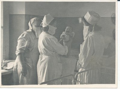 Ämmaemand Maimo Väin hoiab käes imikut Valga sünnitusosakonnas 1940-ndatel. 36 Valga Haiglas töötatud aasta jooksul võttis ta vastu 2813 last.