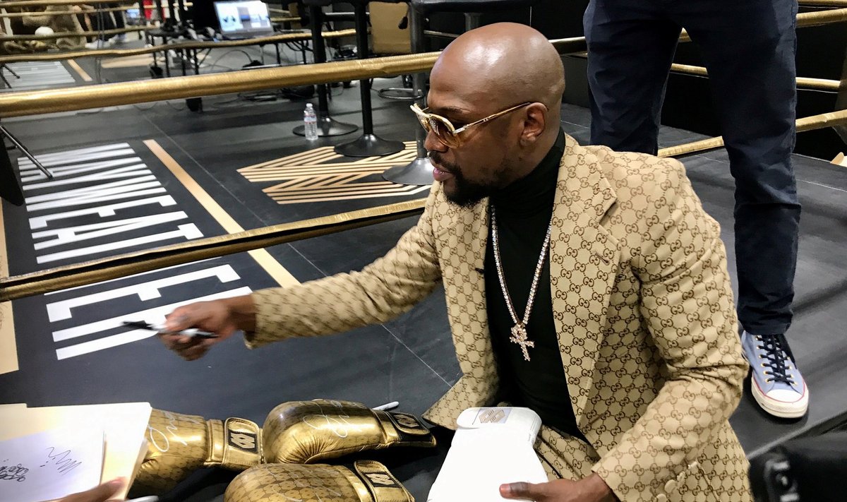Floyd Mayweather signs gloves at the opening of the Mayweather Boxing + Fitness gym in Torrance
