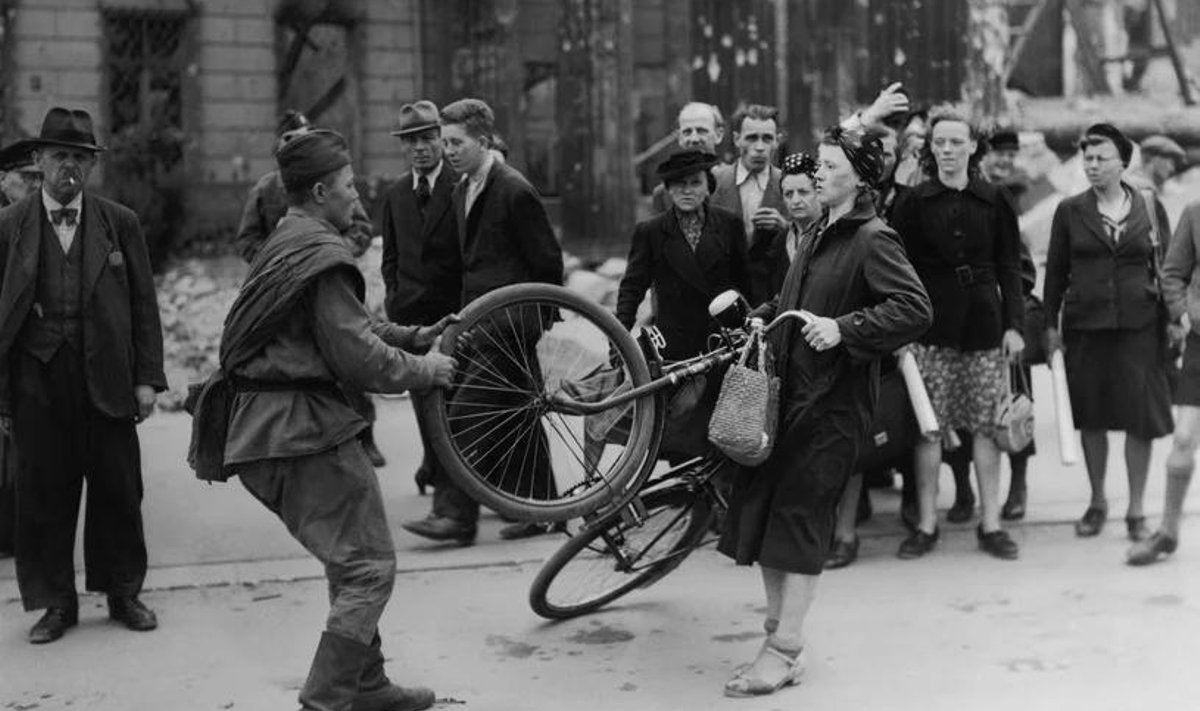 Punaarmeelane Berliini naiselt jalgratast ära võtmas.