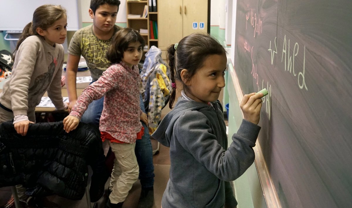 Süüria ja Afganistani põgenike lapsed Berliini koolis kirjutamist õppimas.
