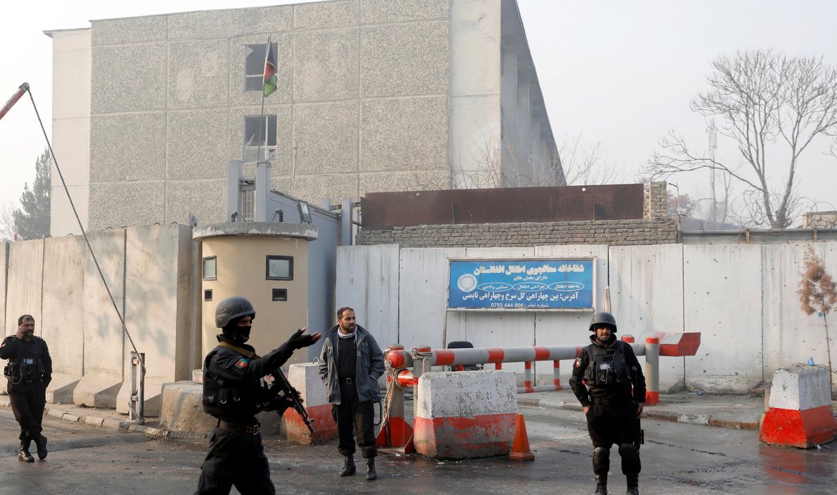 Afghan policemen stand guard outside the government compound after an attack in Kabul