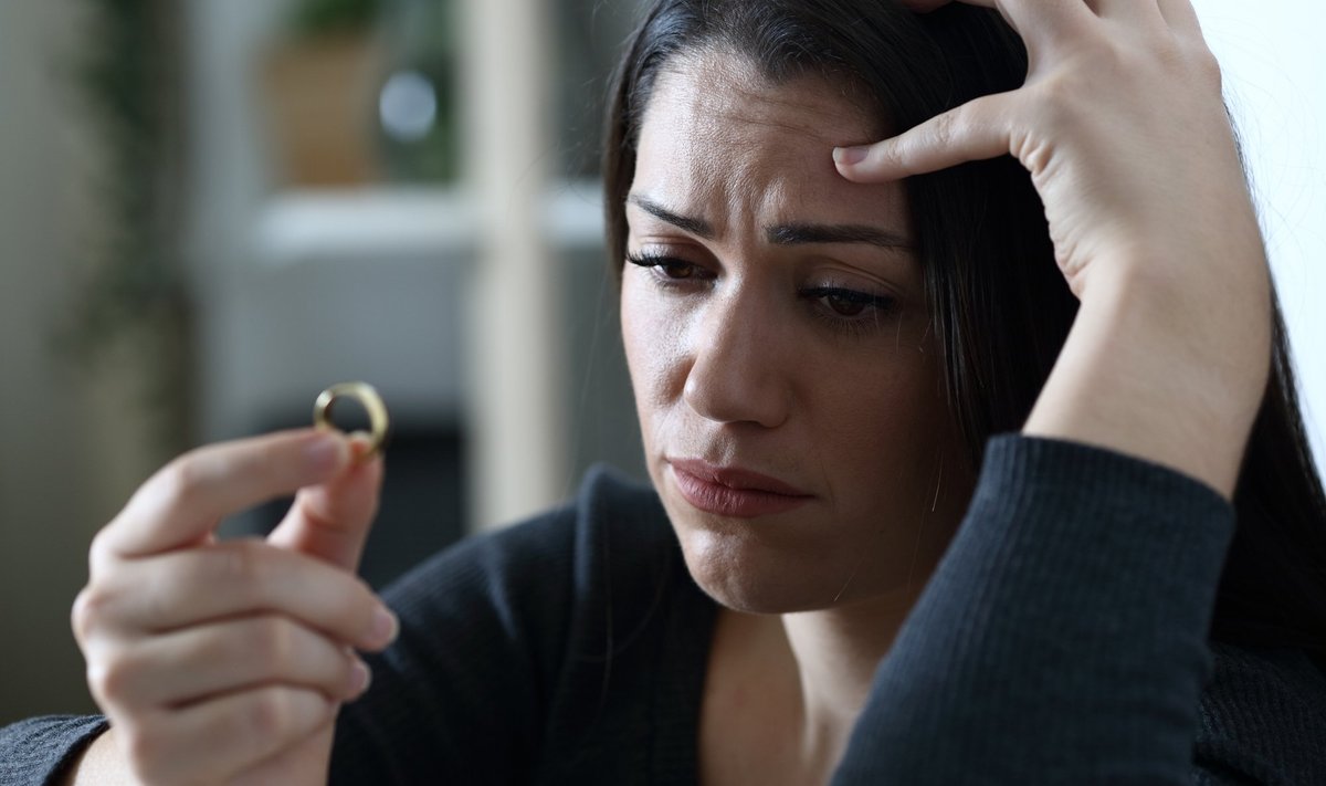 Sad,Doubtful,Wife,Looks,At,Wedding,Ring,Thinking,In,Divorce