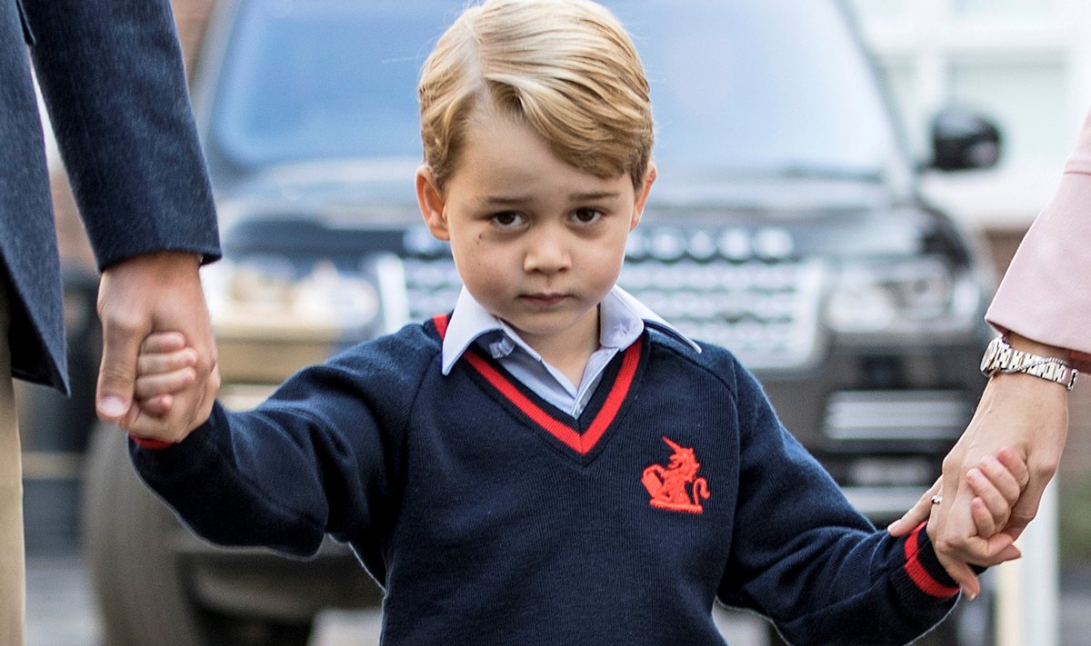Prince George holds his father Britain's Prince William's hand as he arrives on his first day of school at Thomas's school in Battersea, London