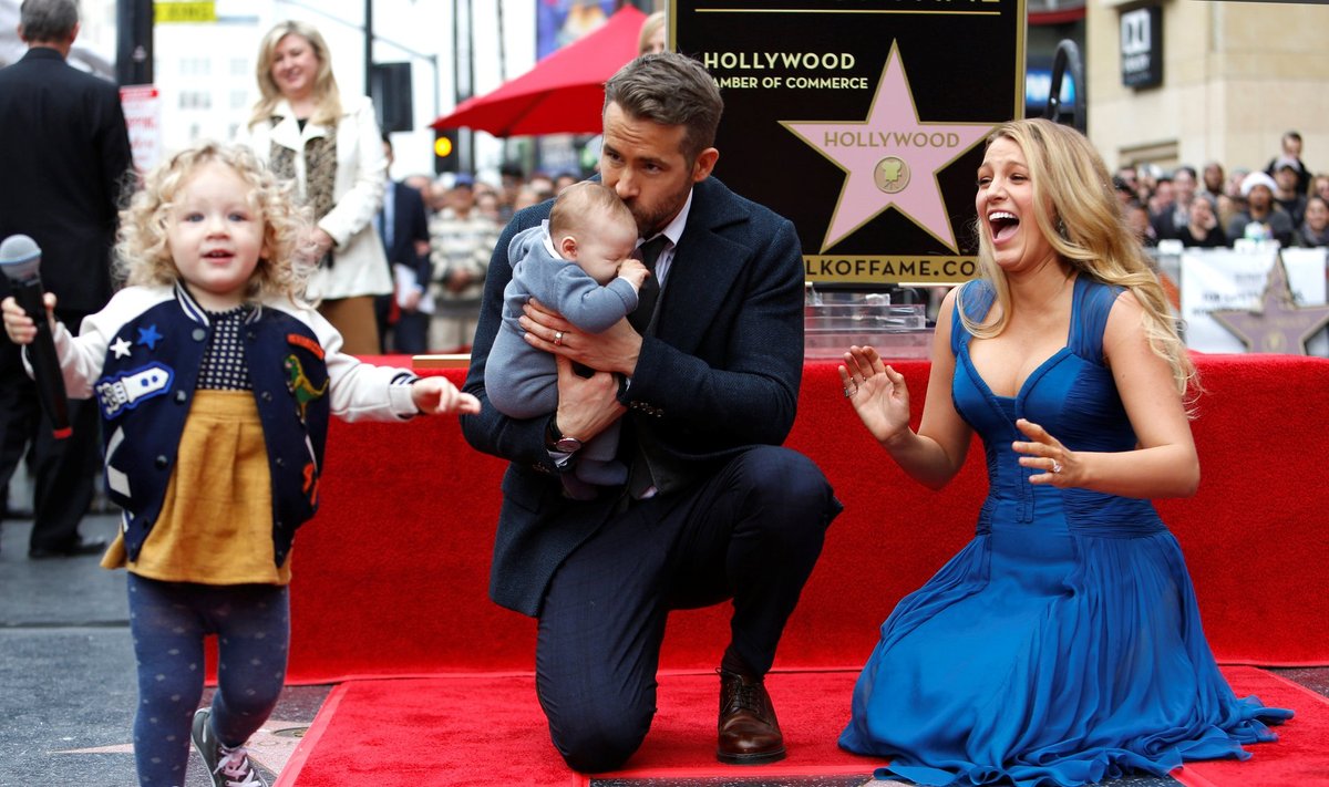 Actor Reynolds kisses his daughter while posing by his star with his wife Lively and their daughter James on the Hollywood Walk of Fame in Hollywood