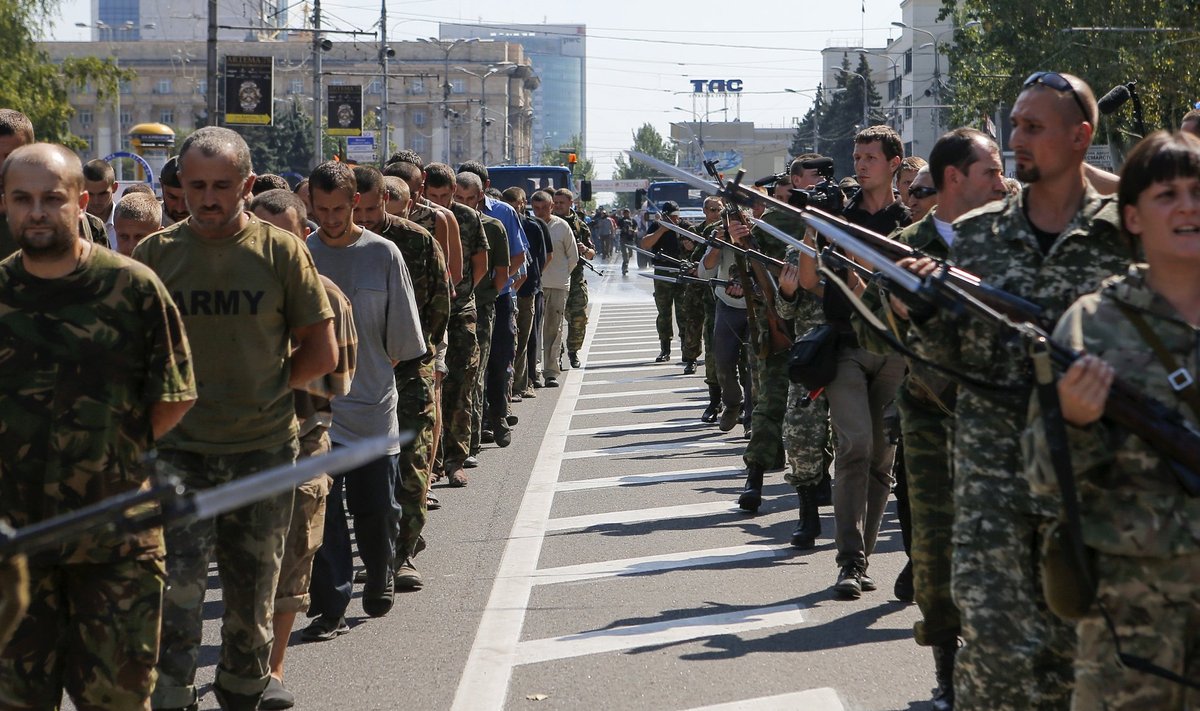 Armed pro-Russian separatists escort a column of Ukrainian prisoners of war as they walk across the centre of Donetsk