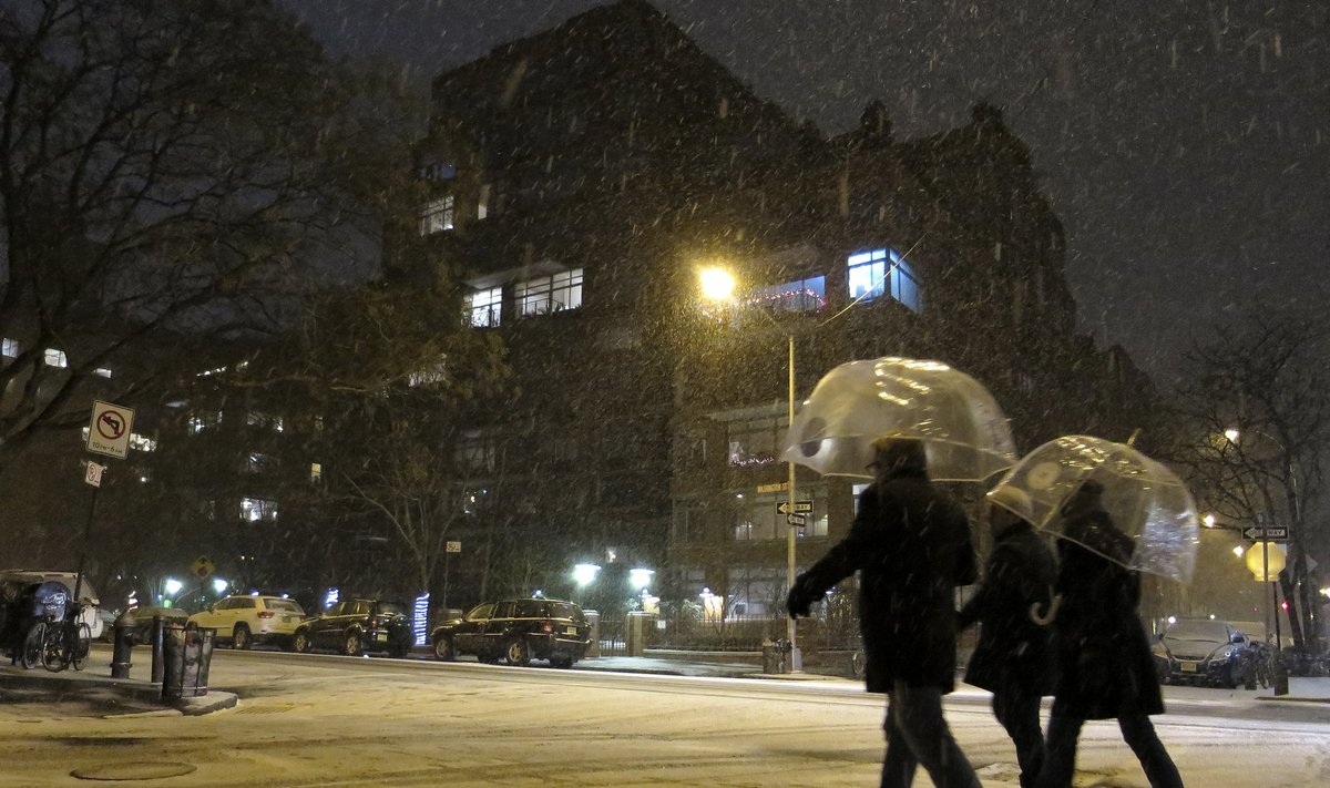 People walk through the West Village neighbourhood as snow begins to fall in New York
