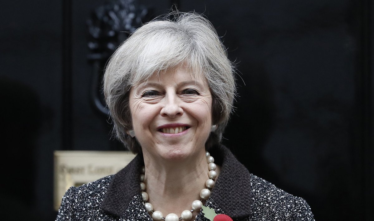 Britain's Prime Minister Theresa May poses with a poppy after buying it to mark this year's Poppy Appeal, at Number 10 Downing Street in central London