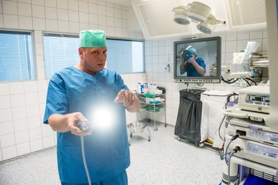 Doktor Mart Niidu näitab laparoskoopilisel operatsioonil kasutatavat ksenoonvalgustusega kaamerat, mis näitab operatsioonilaua monitoride kaudu patsiendi kõhuõõnest selget ja värvilist pilti