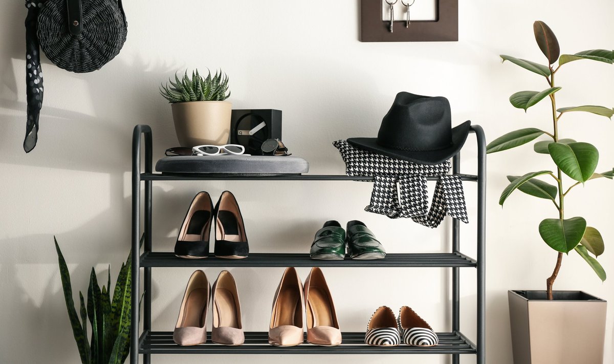 Black,Shelving,Unit,With,Shoes,And,Different,Accessories,Near,White