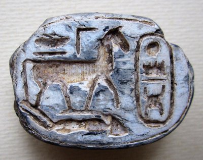 Scarab. 18th Dynasty, reign of Thutmose III (1479–1425 BC). Scarab depicting a horse trampling an enemy. Cartouche with throne name of Thutmose III Menkheperra („Eternal are the manifestations of Ra“) and the royal titles „Perfect God, Lord of the Two Lands“. Steatite, length 37 mm. Collection of Pekka Erelt