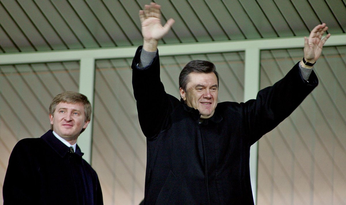 Ukraina tollane peaminister Viktor Janukovitš koos Rinat Ahmetoviga (vasakul) Donetskis Meistrite liiga jalgpallimatšil 2004. aastal.