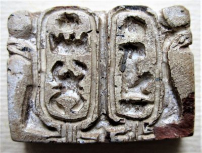 PLAADIKUJULINE AMULETT: 18. dünastia, vaarao Thutmosis III ja Hatshepsuti koosvalitsus (1479–1425 eKr).  Plaadi ühel küljel vaaraode Thutmosis III ja Hatshepsuti kartušid, teisel küljel vibuga vaarao lahingus, tema kohal Thutmosis III kartušš. Steatiit, 20x28  mm. Pekka Erelti kogu
