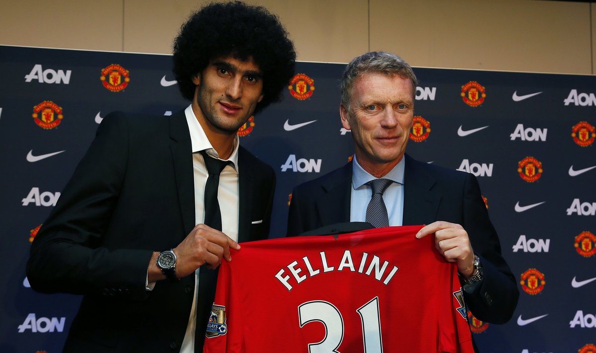 Manchester United's new signing Fellaini poses with manager Moyes and a club shirt ahead of a news conference at the club's Old Trafford stadium in Manchester