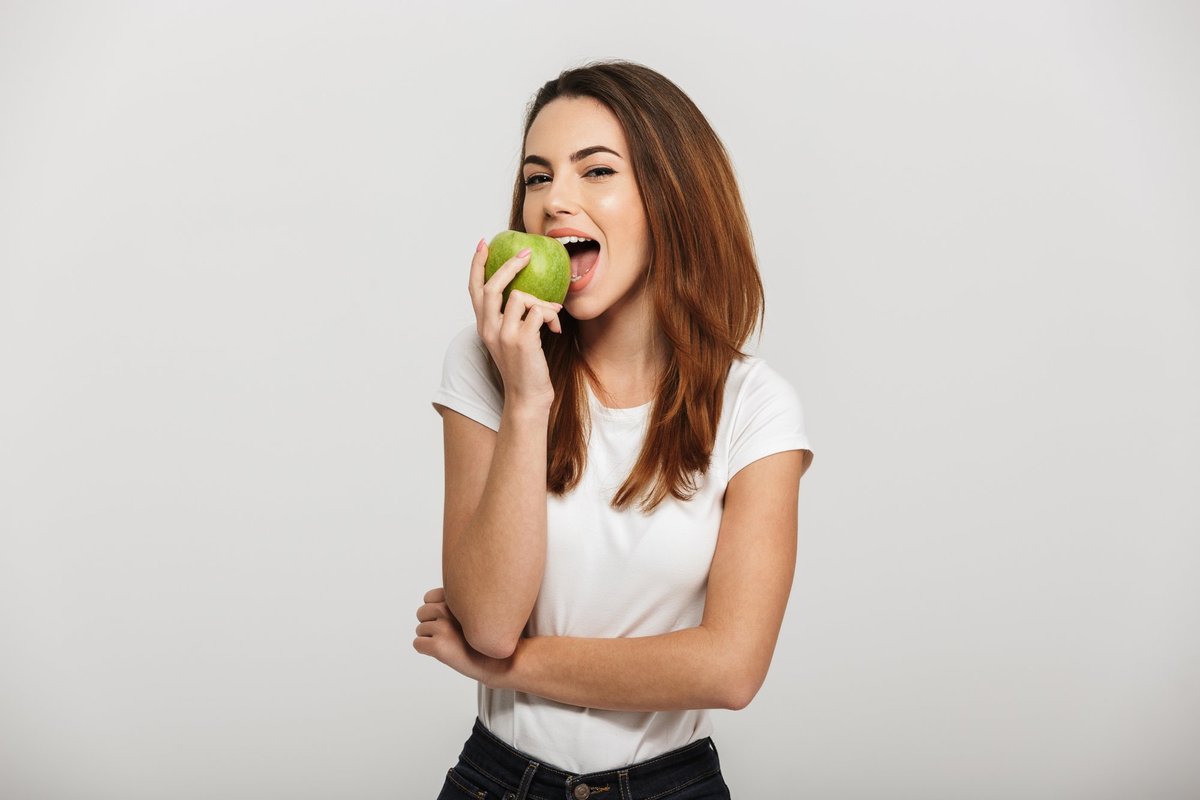 Кидает яблоко. Девушка ест яблоко. Человек ест яблоко. Девушка с зеленым яблоком. Девушка ест.