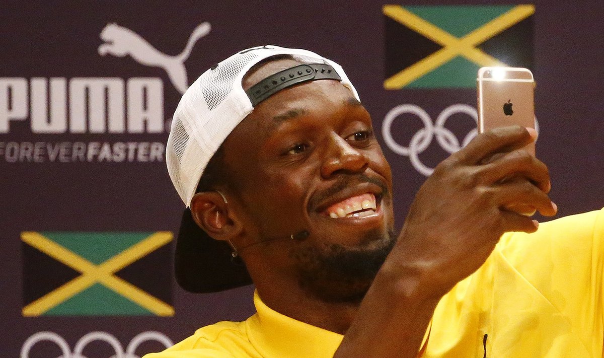 Usain Bolt uses an Apple iPhone while giving a press conference
