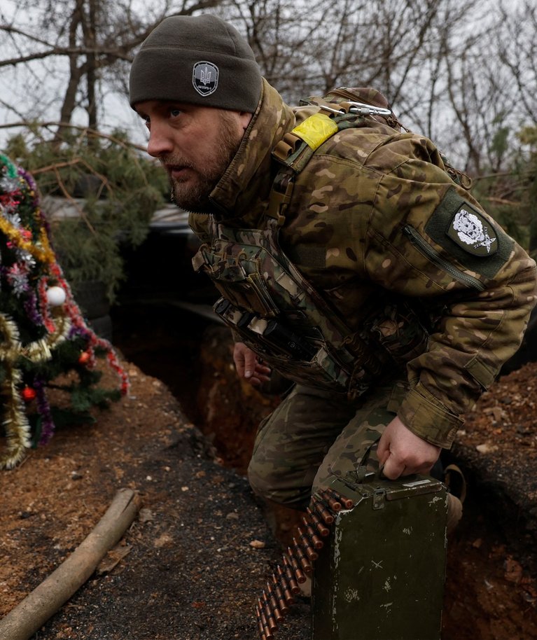 Ukraina sõjaväelane rindejoone kaevikus ehitud jõulupuu kõrval. Foto tehtud Bahmutis 24. detsembril 2022.