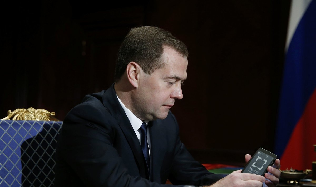 Russia's Prime Minister Dmitry Medvedev holds a YotaPhone smartphone during a meeting with Sergei Chemezov, CEO of Rostec State Corporation, at the Gorki residence outside Moscow