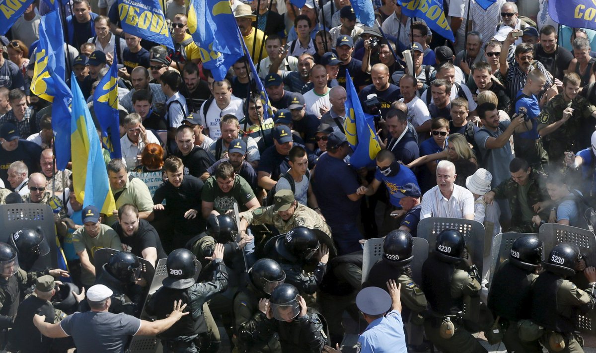 Demonstrators, who are against a constitutional amendment on decentralization, clash with police outside the parliament building in Kiev