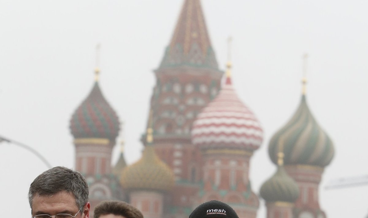 People visit the site where Boris Nemtsov was shot dead, with St. Basil's Cathedral seen in the background, in central Moscow