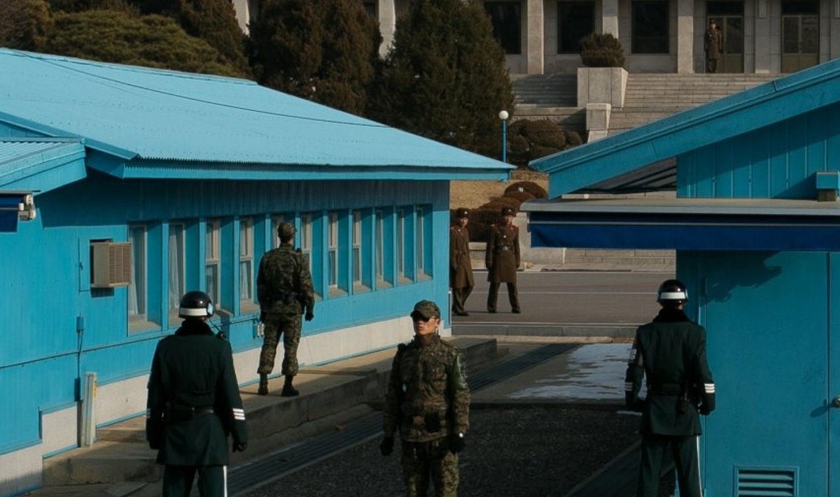 Betoonkõrgendik majade vahel on piir. Taustal Põhja-Korea sõdurid. 