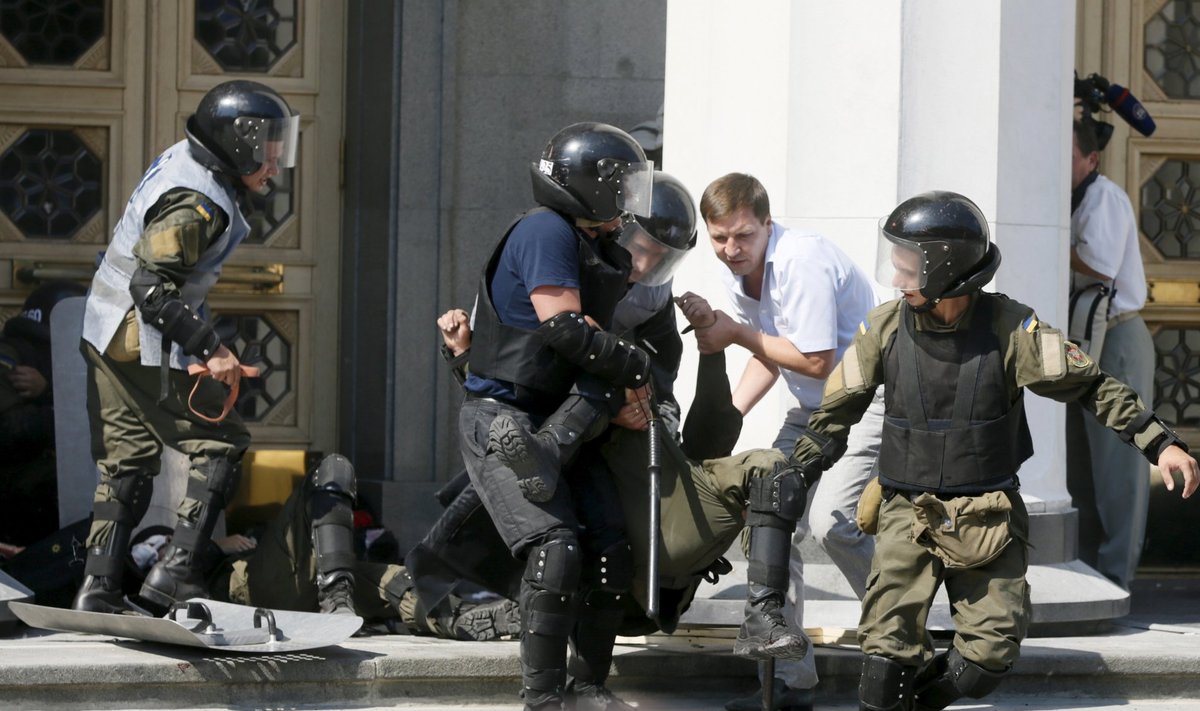 Ukrainian servicemen carry an injured comrade away from the parliament building in Kiev, Ukraine