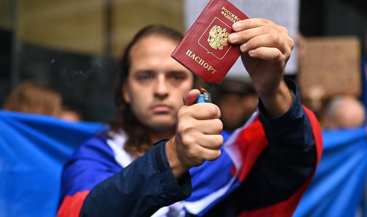 Мужчина сжигает свой паспорт в знак протеста против российской агрессии в Украине