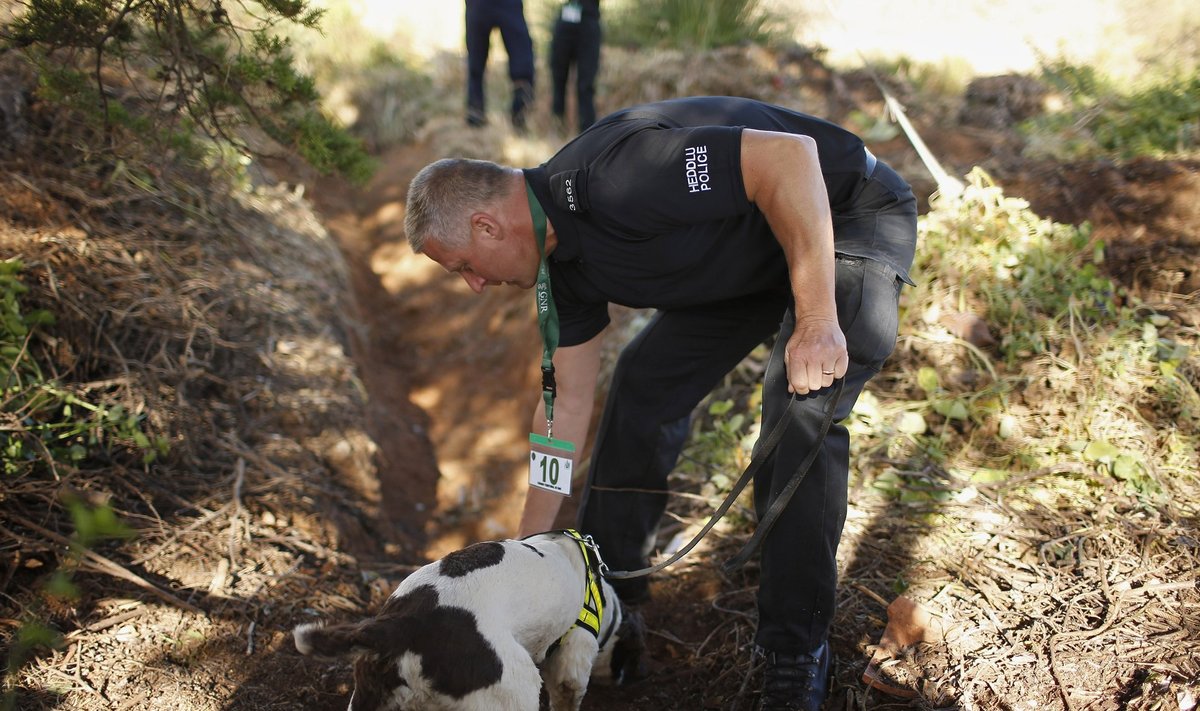 Politseinik juhendab väljakaevamisel koera