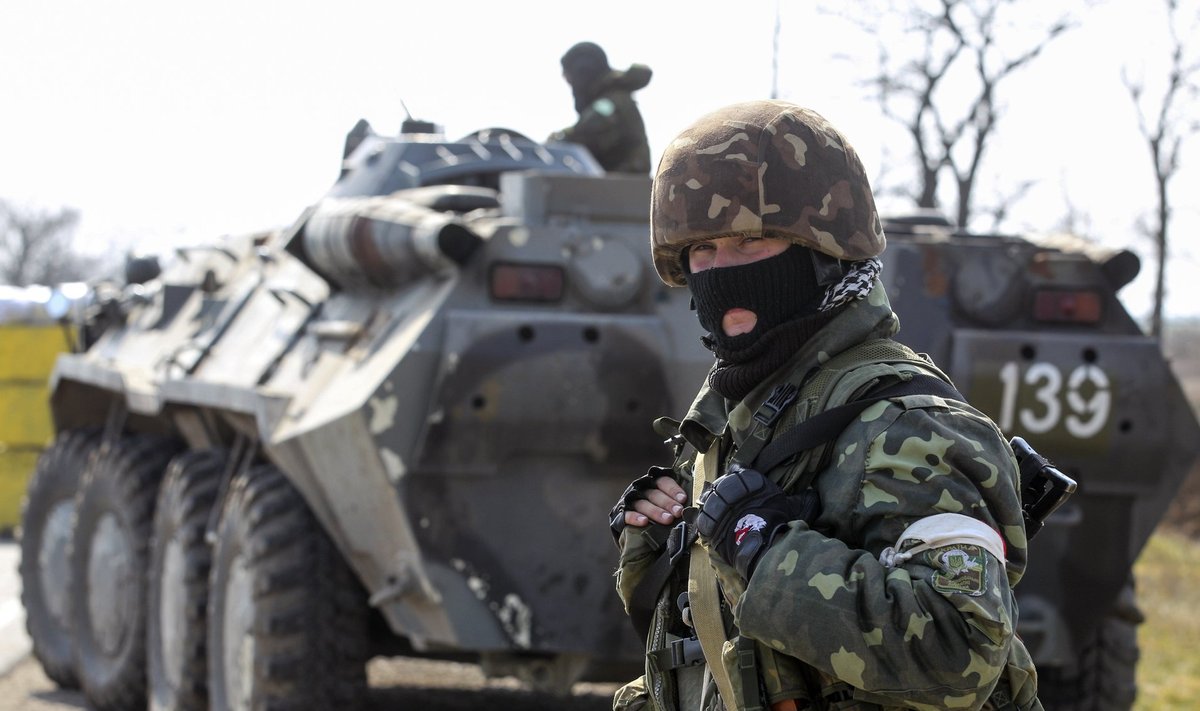 A Ukrainian serviceman stands guard near a check point outside the village of Chongar in Kherson region