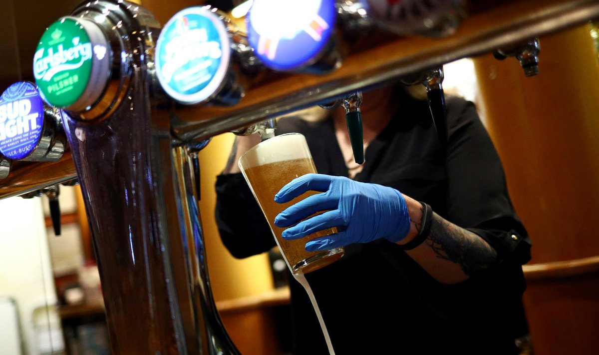 Londoni pubitöötaja juulikuise taasavamise järel õlut valamas
