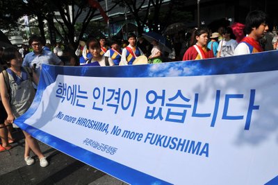 South Korean activists carry a banner reading "No more Hiroshima, No more Fukushima" 