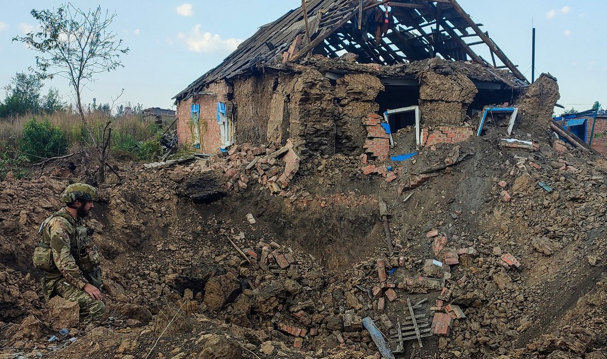 Ukraina sõdur uurimas Vene planeerivast pommist jäänud kraatrit.