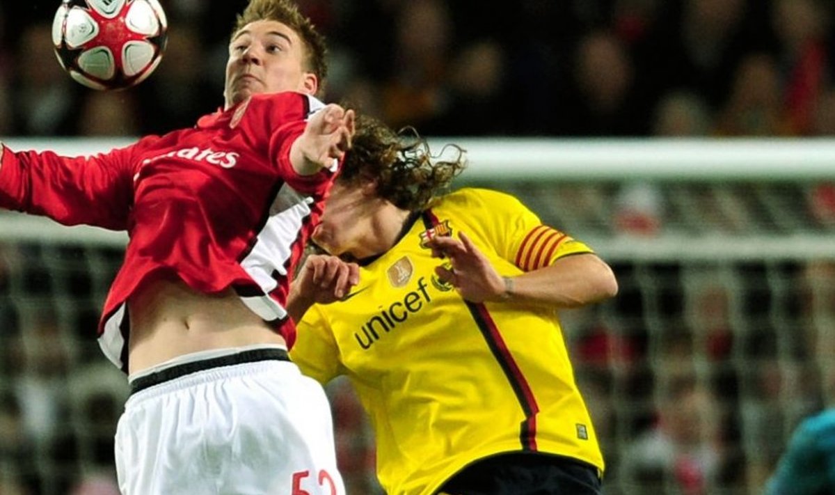 Arsenal's Danish player Niklas Bendtner (L) vies for the ball against Barcelona's captain Carles Puyol during the UEFA Champions League quarter-final 1st leg football match against Arsenal at the Emirates Stadium, in London on March 31, 2010. The game ended 2-2. AFP PHOTO/ADRIAN DENNIS