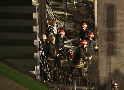 Firefighters move a body out from the collapsed Maxima supermarket in Riga