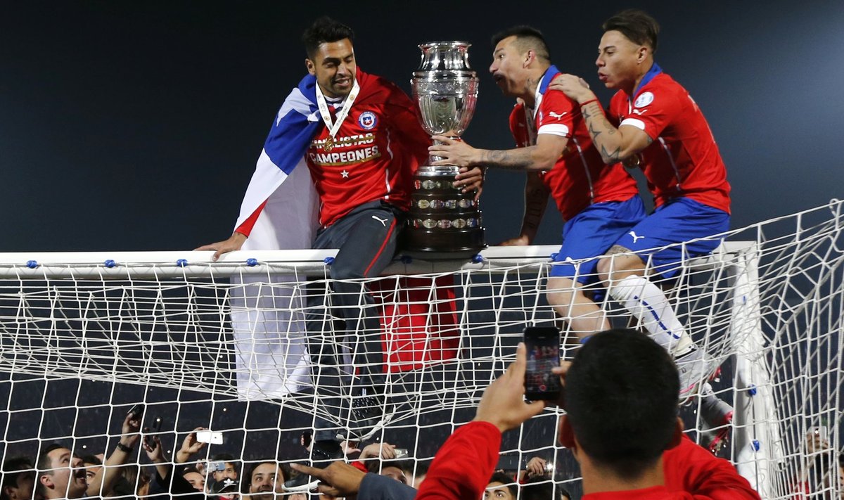 Chile celebrates with the trophy on the goal after defeating Argentina to win the Copa America 2015 final soccer match at the National Stadium in Santiago